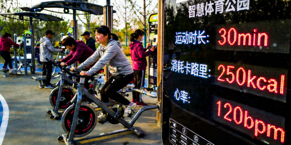 智慧体育公园内市民使用智能健身器材与数据大屏的场景